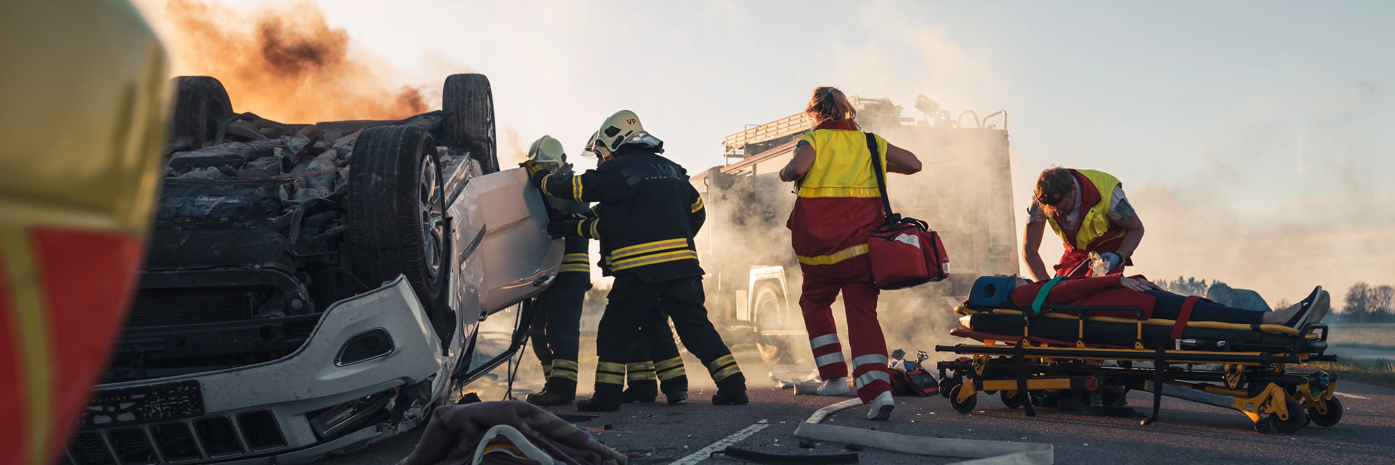 The image shows firefighters and paramedics responding to a crash scene, representing Cover Thread's focus on building high quality first responder socks.