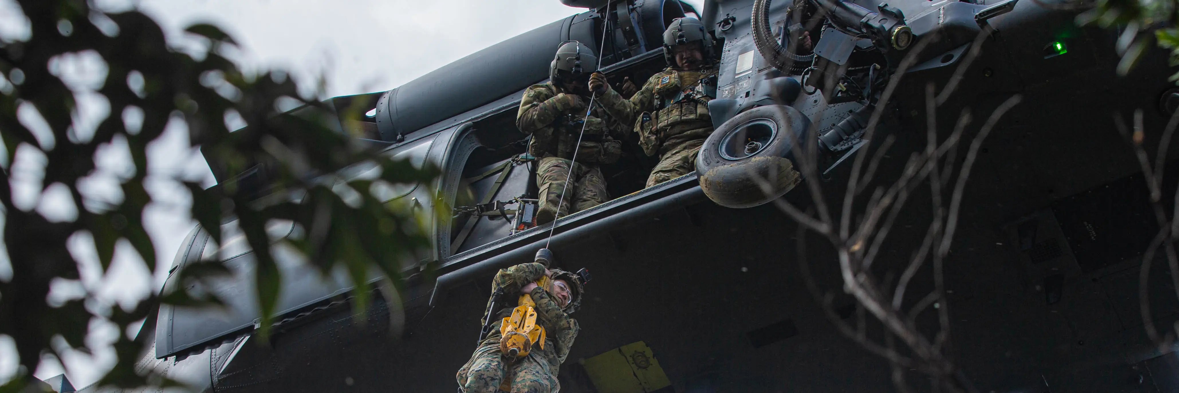The image shows military members repelling out of a helicopter, representing Covert Threads' background in building military socks. 