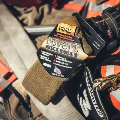 The USA-made Covert Threads Fire Sock shown in its packaging on turnout gear